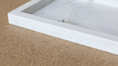 Rear view of Nothing To Hold showing the white-painted timber brace and attached hanging string, ready to hang unframed.
