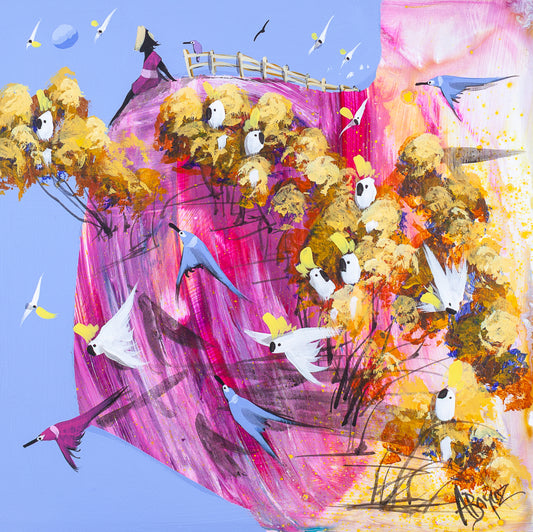 Open Hands, original acrylic painting on board by Adam Bogusz. Magenta and gold landscape against a soft blue sky, with a woman in pink sitting at the very edge of the hill with her legs over, a fence running behind her with a small bird on the end post, and sulphur crested cockatoos gathered in golden trees and flying below.