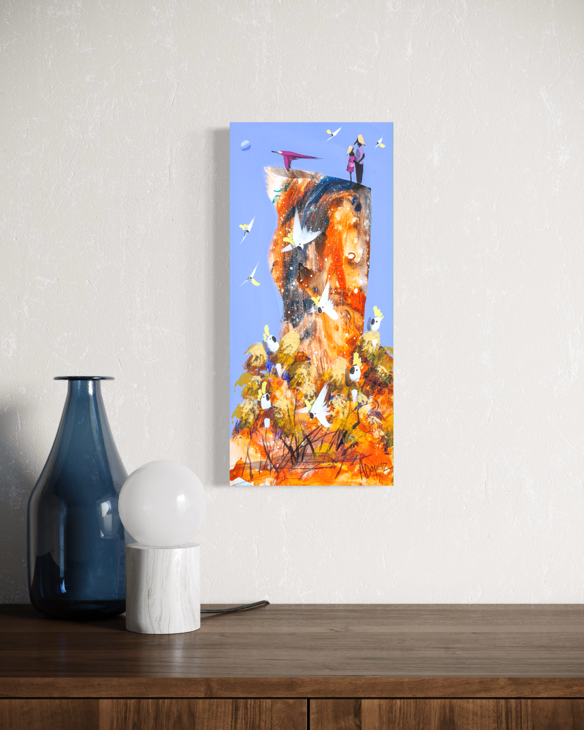 Side by Side by Adam Bogusz hanging unframed on a pale textured wall above a dark timber sideboard with a blue glass bottle and globe lamp, showing the scale of the painting in a room.