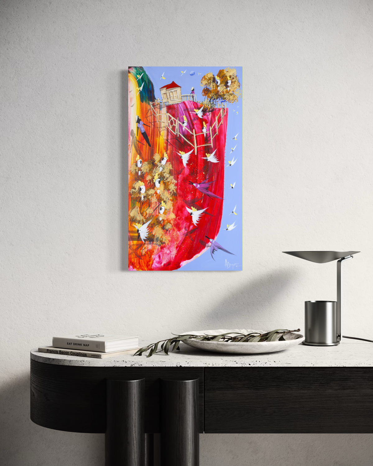 Still in Sight by Adam Bogusz hanging unframed on a pale wall above a black and travertine console with books, a stone bowl and a metal lamp, showing the scale of the painting in a room.