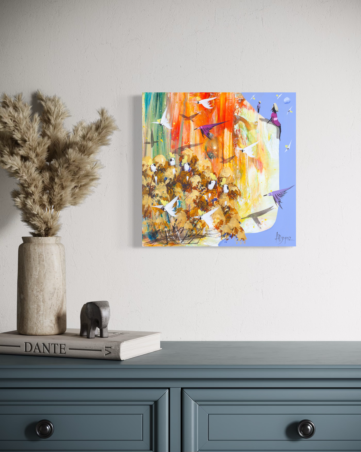 Nothing to Catch by Adam Bogusz, square cockatoo painting on MDF board hanging above a blue grey dresser beside a vase of dried pampas grass, showing a golden landscape with cockatoos and a girl in pink seated against a blue sky.