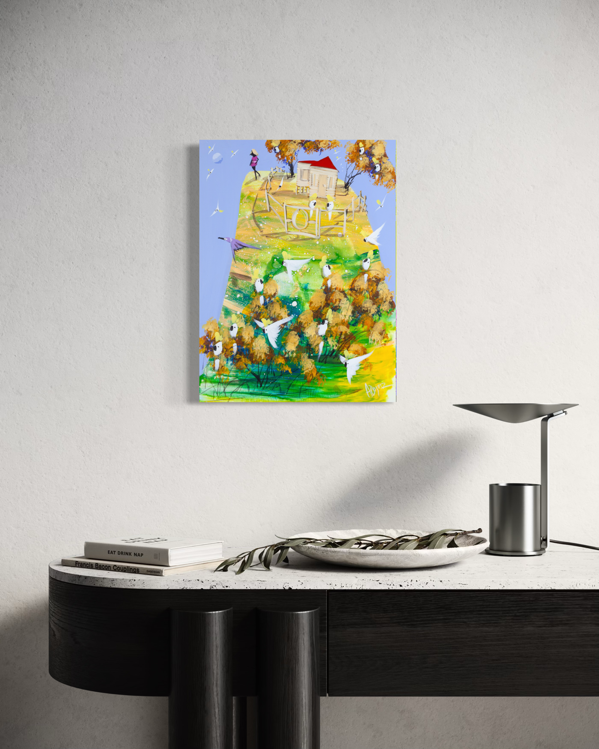 When She's Ready by Adam Bogusz hanging unframed on a pale wall above a black and travertine console with books, a stone bowl and a metal lamp, showing the scale of the painting in a room.