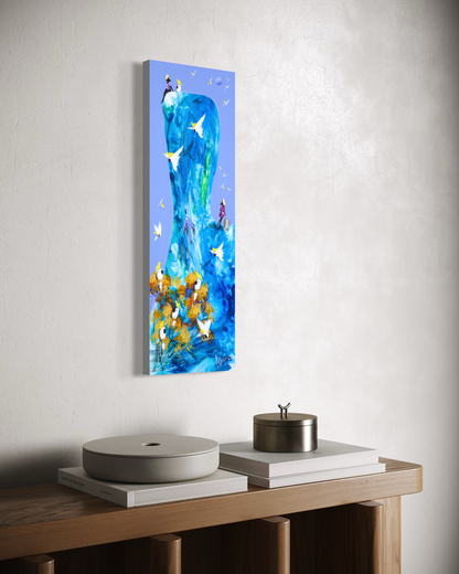 The Same Blue by Adam Bogusz hanging unframed on a pale textured wall above a timber console with books and lidded vessels, seen at a slight angle so the depth of the painted board is visible.