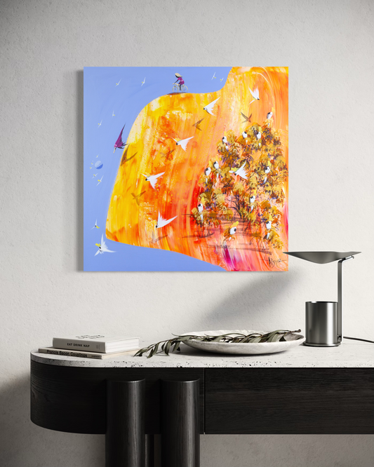 This Is It by Adam Bogusz hanging above a black console with a stone top, a table lamp, books and a bowl of eucalyptus leaves, shown to scale in a living space.